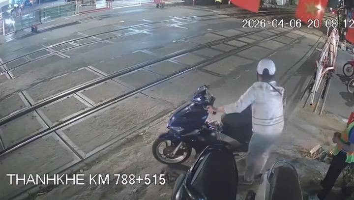 Người phụ nữ cố tình dắt xe vượt rào chắn.