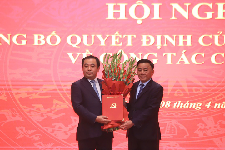 Thường trực Ban Bí thư Trần Cẩm Tú trao quyết định của Bộ Chính trị và tặng hoa chúc mừng tân Bí thư Thành ủy Hà Nội Trần Đức Thắng.