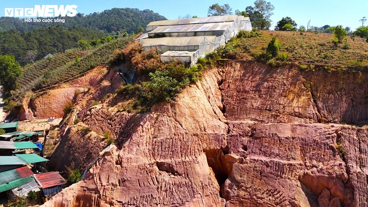 Nhiều vết nứt chạy dọc, ngang trên khắp bề mặt quả đồi phía trên nhà dân giống "bom nổ chậm" đợi mưa gió kích hoạt.