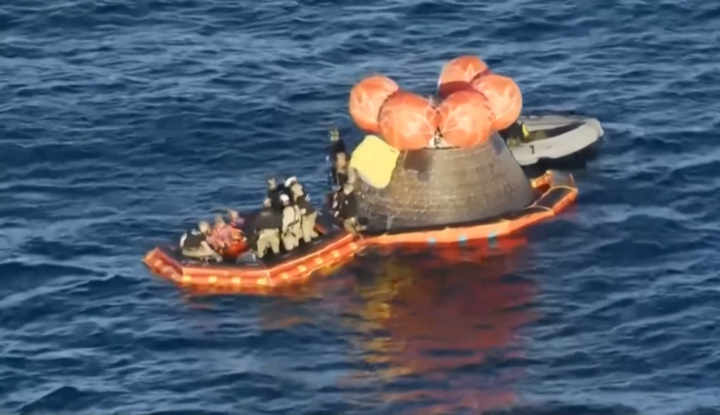 Đội cứu hộ đưa hai phi hành gia đầu tiên rời khỏi khoang lên xuồng nổi.