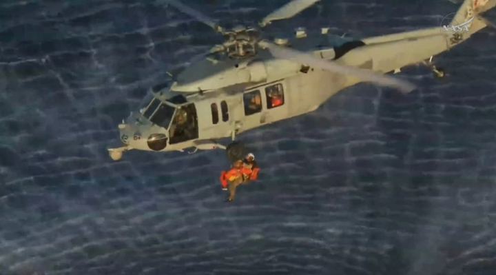 Phi hành gia Reid Wiseman, chỉ huy nhiệm vụ Artemis II, được đưa lên trực thăng quân sự của Mỹ để được vận chuyển đến tàu USS John P. Murtha. (Ảnh: NASA)