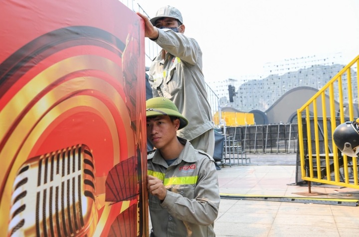 Đó là quá trình lao động nghiêm túc, sáng tạo, nơi mỗi âm thanh, mỗi câu chữ đều được chăm chút để chạm tới cảm xúc người nghe. (Ảnh: Công nhân thực hiện những khâu cuối trước giờ khai mạc)