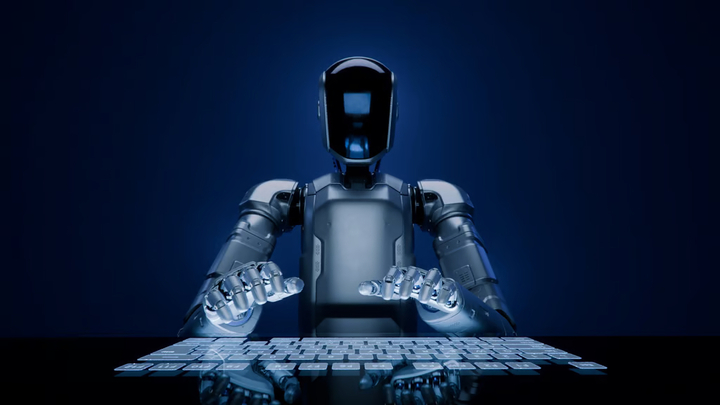 Một robot hình người được trang bị trí tuệ nhân tạo với tấm che mặt bằng kính đang gõ trên bàn phím cảm ứng hiện đại.