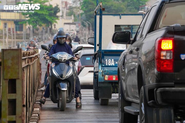 Không chỉ hẹp, kết cấu cầu phao cũng tiềm ẩn nhiều rủi ro. Các điểm nối giữa những phao nổi bồng bềnh, kết hợp với đường dẫn lên xuống dốc khiến việc di chuyển trở nên khó khăn, đặc biệt với xe chở hàng hoặc phương tiện cồng kềnh. Nhiều người đi xe máy phải len lỏi giữa các ô tô tải, xe chở hàng cồng kềnh, tiềm ẩn nguy cơ va chạm bất cứ lúc nào.