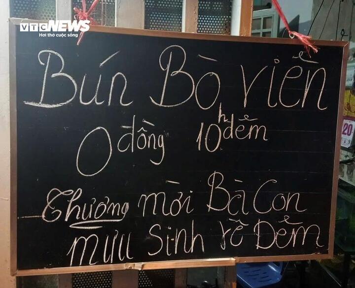 Tấm bảng nhỏ ghi thực đơn trong ngày, kèm lời mời giản dị dành cho người lao động mưu sinh về đêm ghé dùng bữa.