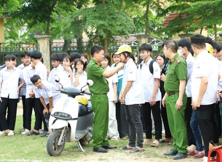 Công an xã Tân Thanh hướng dẫn kỹ năng đội mũ bảo hiểm đúng cách cho học sinh.