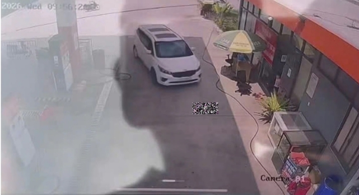 Bé gái nằm chơi tại lối đi của cây xăng.