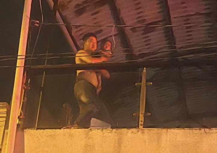 Hình ảnh Đại úy Huỳnh Tuấn Kiệt - Cán bộ Tổ Cảnh sát Phòng chống tội phạm Công an phường Tân Thới Hiệp băng qua lửa cứu cháu bé 18 tháng tuổi.