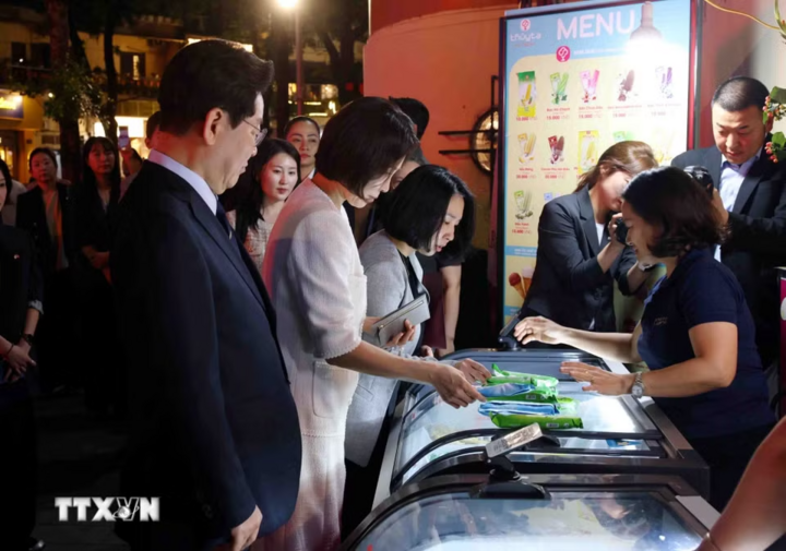 Tổng thống Hàn Quốc Lee Jae Myung và Phu nhân Kim Hae Kyung dừng chân mua kem Thủy Tạ tại khu vực hồ Hoàn Kiếm. (Ảnh: Phạm Kiên/TTXVN)