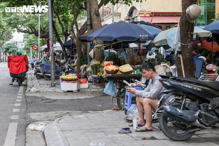 Nhiều hộ kinh doanh đã chủ động lùi hàng hóa vào khoảng một nửa vỉa hè, song việc để xe máy kèm theo vẫn chiếm dụng không gian, cản trở lối đi của người đi bộ.