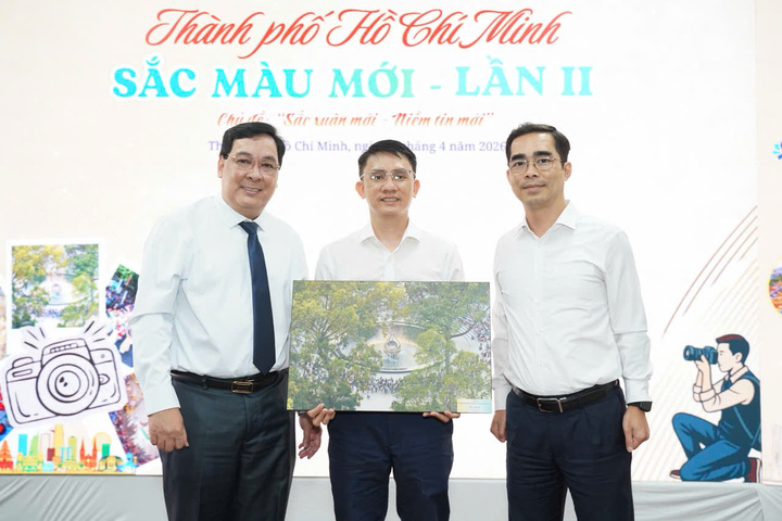 Nhiếp ảnh gia Tống Trần Sơn (ở giữa) nhận giải nhất cuộc thi “TP.HCM - Sắc màu mới”.