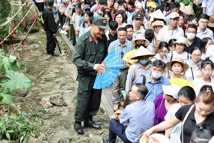 Một du khách lớn tuổi được chiến sĩ Cảnh sát cơ động "tiếp sức" trong lúc ngồi nghỉ ngơi giữa hành trình.