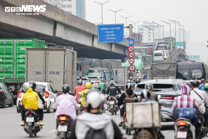 Ở khu vực lối lên cao tốc trên đường Khuất Duy Tiến, mật độ phương tiện cao, trong đó có nhiều xe tải và container.