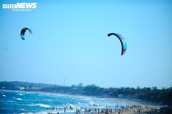 Một góc biển Mũi Né sôi động với bãi biển đẹp và trò chơi dù lượn hấp dẫn du khách.