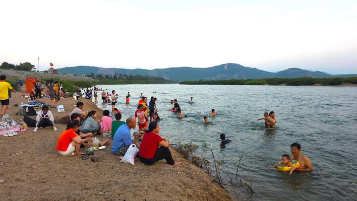 Những ngày nắng nóng, khu vực bãi bồi ven bờ kè sông Ba, đoạn qua xã Sơn Hòa (tỉnh Đắk Lắk) trở nên nhộn nhịp hơn bao giờ hết. Từng nhóm bạn trẻ, gia đình mang theo lều trại, đồ ăn, kéo nhau ra đây nghỉ mát, vui chơi, tạo nên khung cảnh sôi động như một bãi biển thực thụ giữa vùng núi.