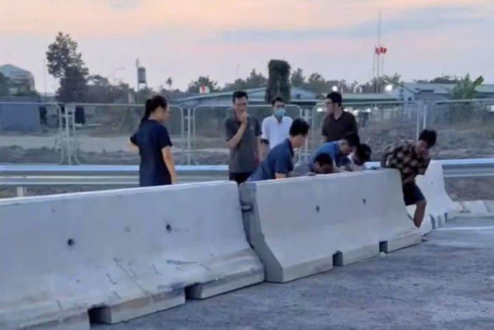 Nhiều người tìm cách di chuyển khối bê tông để lưu thông ở cao tốc Biên Hòa - Vũng Tàu. (Ảnh cắt từ clip)