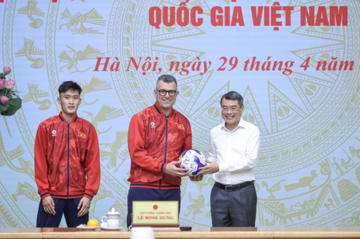 Đại diện đội tuyển bóng đá nam U17 Quốc gia Việt Nam tặng bóng cho Thủ tướng Lê Minh Hưng - Ảnh: VGP/Nhật Bắc