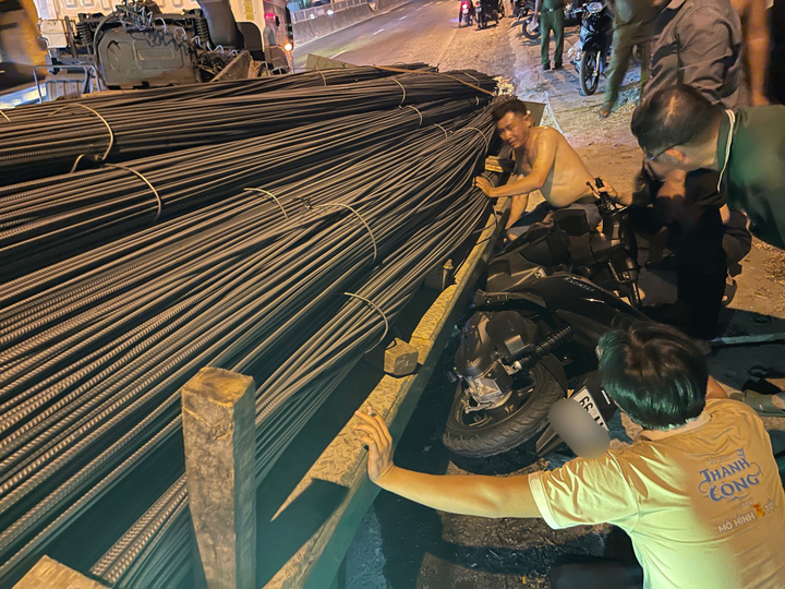 Người dân hỗ trợ đưa xe máy ra ngoài gầm rơ-moóc.