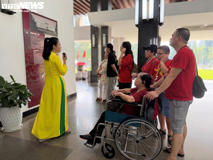 Ba thế hệ trong gia đình cùng có mặt tại Dinh Độc Lập. Con cháu thay nhau đẩy xe, cùng lắng nghe hướng dẫn viên kể lại những câu chuyện lịch sử.