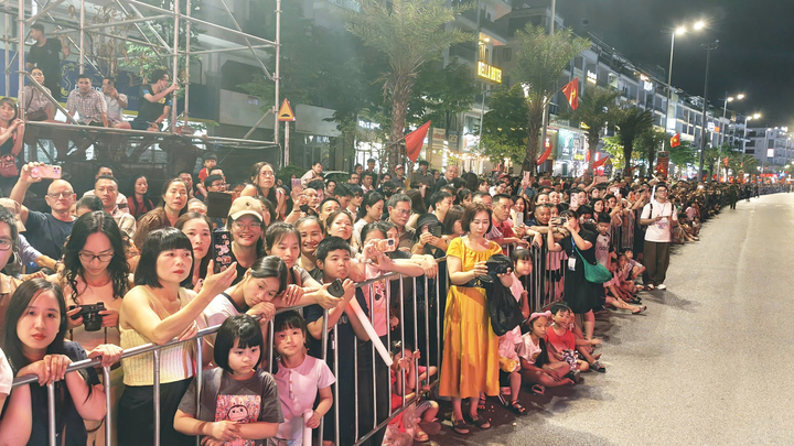 Người dân theo dõi chương trình nghệ thuật dọc hai bên đường Trần Quốc Nghiễn.