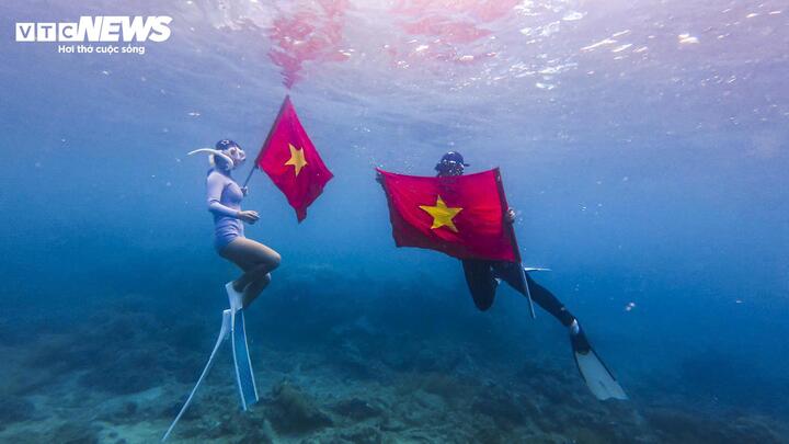 Trong kỳ nghỉ lễ năm nay, nhiều bạn trẻ khi đến Quy Nhơn du lịch đã chọn trải nghiệm cảm xúc check-in dưới biển cùng cờ Tổ quốc.