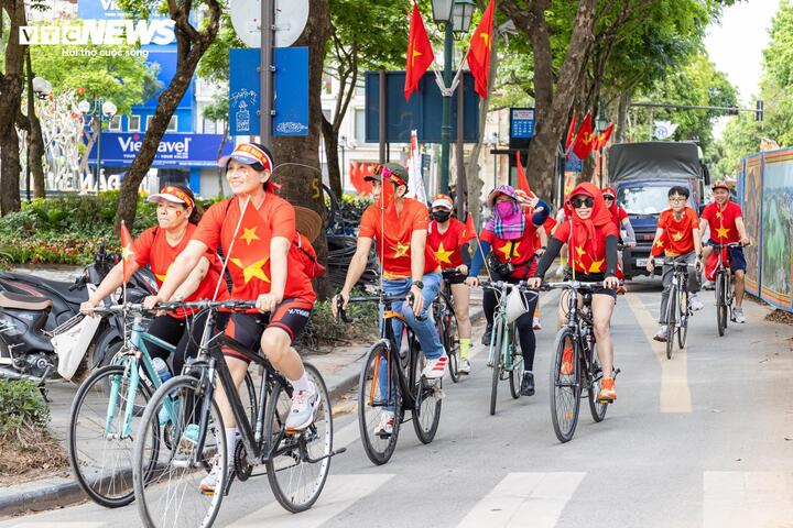 Người dân Hà Nội mặc áo cờ đỏ sao vàng, đạp xe qua các tuyến phố, lan tỏa tinh thần yêu nước dịp nghỉ lễ 30/4. (Ảnh: Minh Đức)
