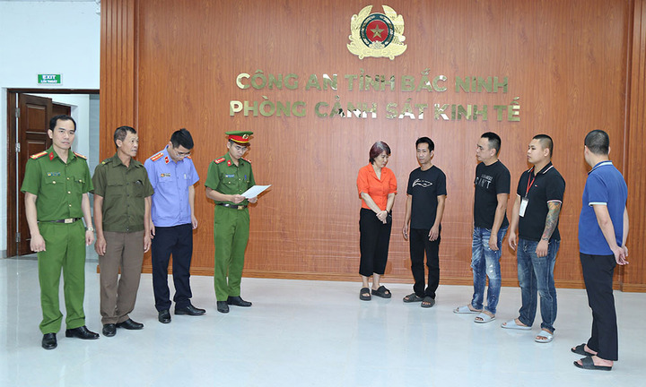 Cơ quan chức năng đọc quyết định khởi tố các bị can phạm tội "sử dụng tài liệu giả của cơ quan, tổ chức". (Ảnh: Như Quỳnh).