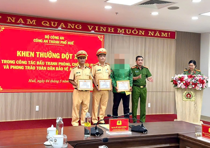 Đại tá Hồ Xuân Phương - Phó Giám đốc Công an TP Huế trao giấy khen cho Trung tá Trần Trọng Vinh, Thiếu tá Hoàng Xuân Tiến và anh N.H.H.