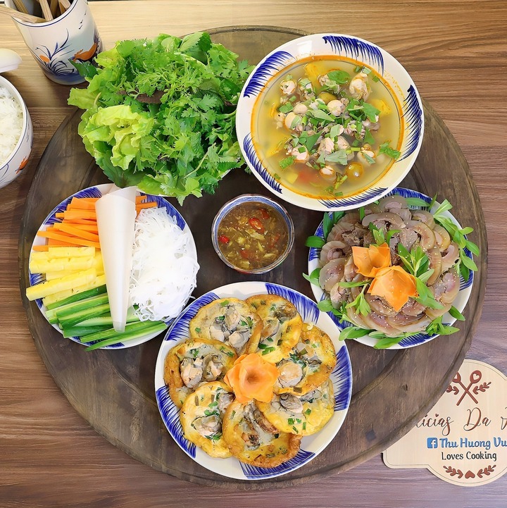 Mâm cơm có món trứng tráng hàu, thịt bê hấp, canh hàu nấu chua.