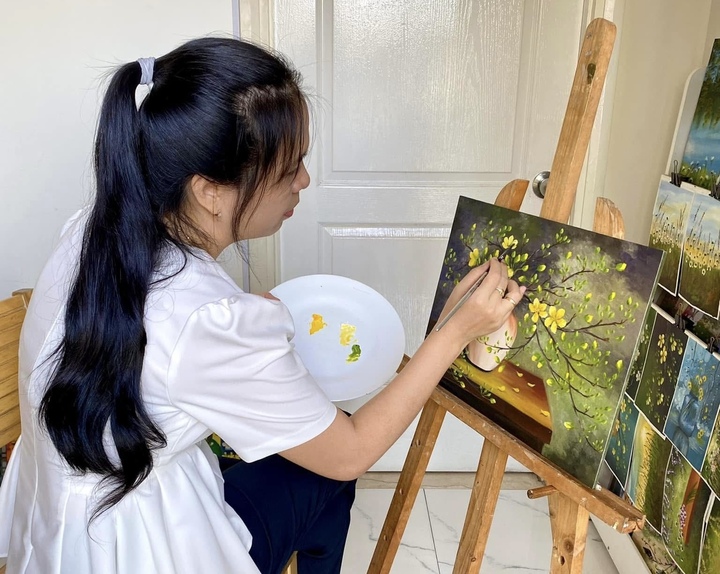 Chị Phạm Thị Giáng Sinh tỉ mỉ vẽ tranh nền trước khi gắn hoa đất sét.