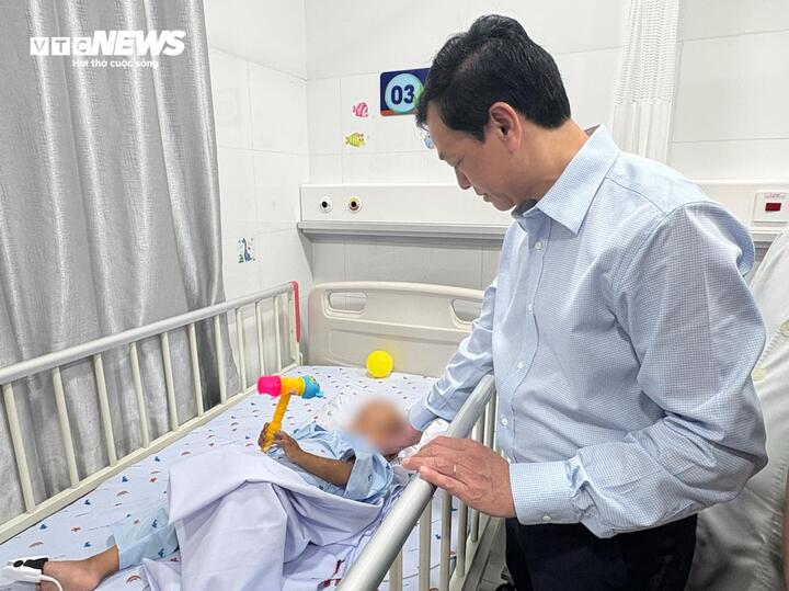Thứ trưởng Bộ Y tế Nguyễn Tri Thức thăm hỏi cháu bé.
