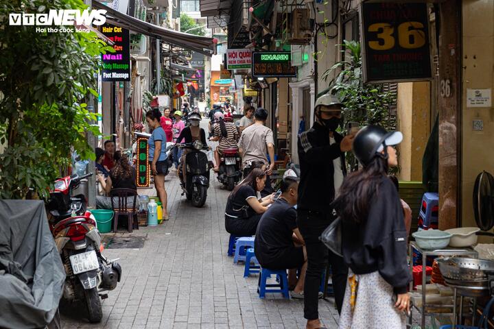 Tại các tuyến ngõ nhỏ, tình trạng lấn chiếm lòng đường, vỉa hè diễn ra phổ biến hơn. Trong ảnh là khu vực ngõ Tạm Thương, nơi nhiều hàng quán bày bàn ghế sát hai bên, chỉ chừa lại lối đi hẹp cho xe máy và người đi bộ di chuyển.
