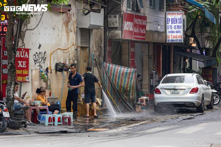 Tuy nhiên, một số khu vực vẫn xuất hiện tình trạng đối phó với lực lượng chức năng. Trong ảnh là cửa hàng rửa xe kết hợp quán nước vẫn tận dụng vỉa hè để phục vụ hoạt động kinh doanh.