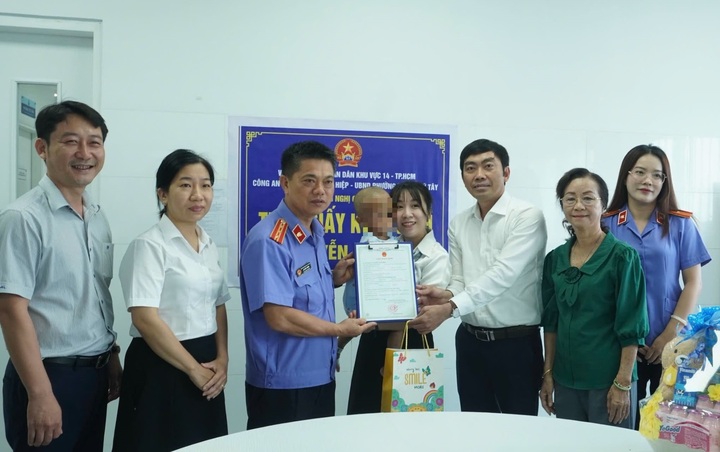 Đo&agrave;n c&ocirc;ng t&aacute;c trao giấy khai sinh cho b&eacute;.