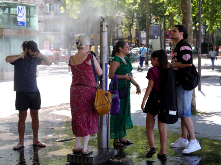 Người dân tìm cách giải nhiệt cạnh vòi phun nước công cộng ở Paris, Pháp. (Ảnh: Getty Images)