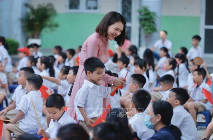 Giáo viên trường tiểu học Gia Quất (Bồ Đề, Hà Nội) đón học sinh đến khai giảng. (Ảnh minh họa: TTXVN)