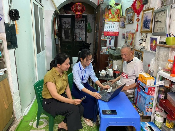 Cán bộ Hà Nội tiếp nhận hồ sơ và hướng dẫn người cao tuổi thực hiện kê khai trực tuyến ngay tại nhà. (Ảnh: Trung tâm phục vụ hành chính công Hà Nội)