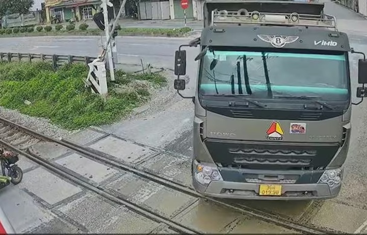 Tài xế xe liều lĩnh lái xe tải tông gác chắn, vượt đường sắt lúc tàu đang tới. (Ẩnh cắt từ clip)