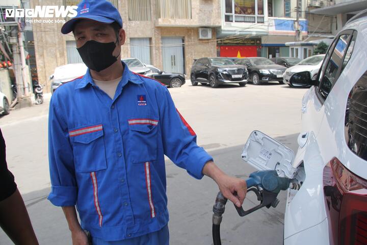 Nhân viên cây xăng giải thích cho khách hàng việc dừng bán xăng RON95.