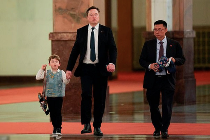Elon Musk nắm tay con trai tại Bắc Kinh. (Ảnh: Reuters)