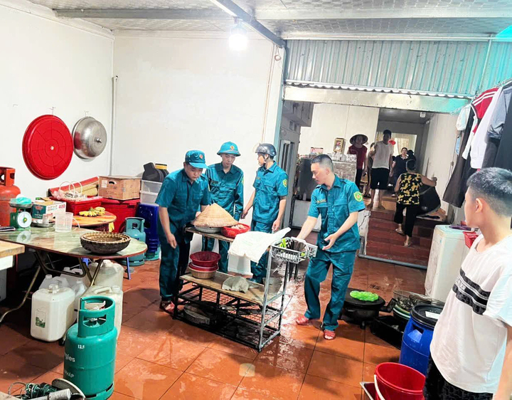 Lực lượng chức năng hỗ trợ người dân tại xã Quảng Hà, tỉnh Quảng Ninh di dời đồ đạc đến nơi an toàn khi nhà cửa khu vực ven sông có dấu hiệu bị sạt lở, sụt lún.