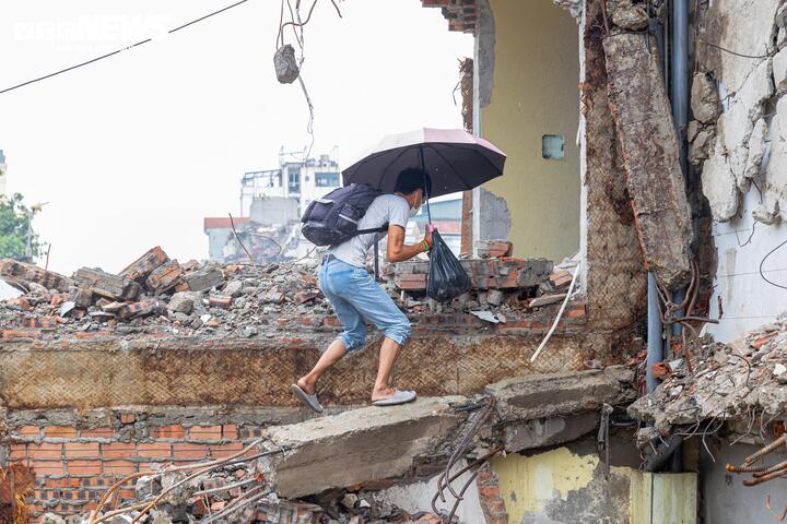 Nhiều căn nhà sau khi bị phá dỡ một phần vẫn tiếp tục là nơi sinh sống của gia chủ. Hằng ngày, họ phải chật vật bước, trèo qua các đống đất đá, bê tông và sắt thép ngổn ngang để ra vào nhà.