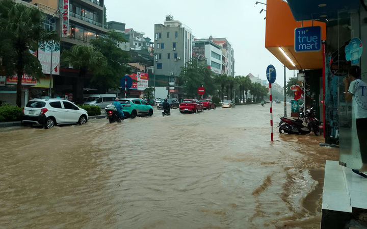 Các phương tiện chật vật di chuyển qua khu vực ngập nước tại tuyến đường Kênh Liêm.