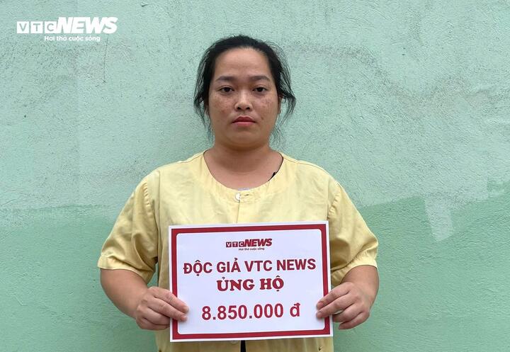 Chị Nguyễn Thị Năm vợ anh Hiển đón nhận sự giúp đỡ từ bạn đọc. (Ảnh: Khắc Việt)