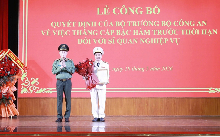 Thượng tướng Lê Quốc Hùng, Ủy viên Trung ương Đảng, Thứ trưởng Bộ Công an, trao Quyết định, tặng hoa chúc mừng Đại tá Vũ Thanh Tùng (bên phải). (Ảnh: LS)