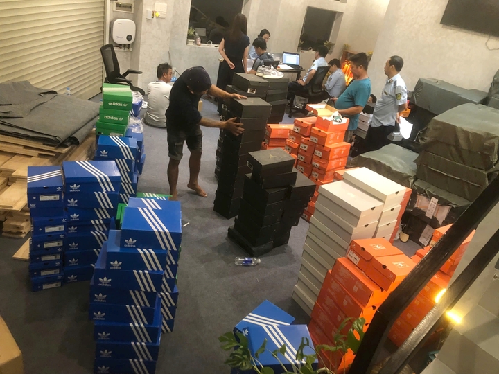 Lực lượng chức năng phát hiện số lượng hàng hóa giả thương hiệu. (Ảnh: Công an cung cấp)