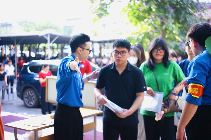 Lực lượng tình nguyện “Tiếp sức mùa thi 2026” hỗ trợ hướng dẫn thí sinh tại khu vực cổng trường.