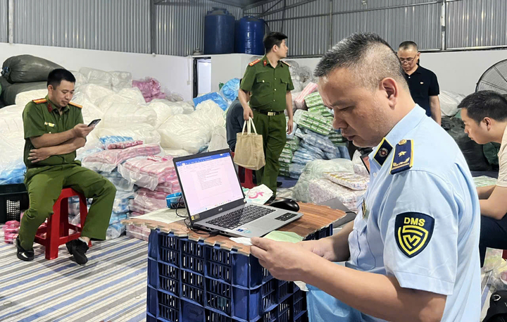 Cơ quan chức năng lập biên bản tại cơ sở sản xuất hơn nửa triệu miếng băng vệ sinh đạo nhái các thương hiệu nổi tiếng. (Ảnh: Trần Thế Mạnh)
