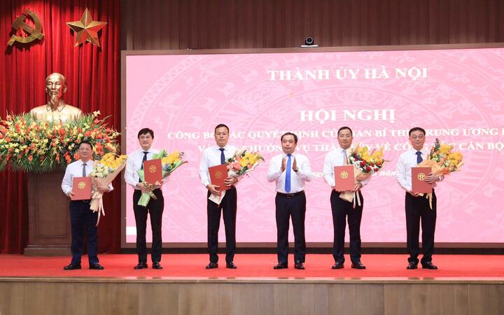 Bí thư Thành ủy Hà Nội Trần Đức Thắng trao quyết định của Ban Bí thư Trung ương Đảng về công tác cán bộ và tặng hoa chúc mừng các cán bộ nhận nhiệm vụ mới. (Ảnh Quang Thái)