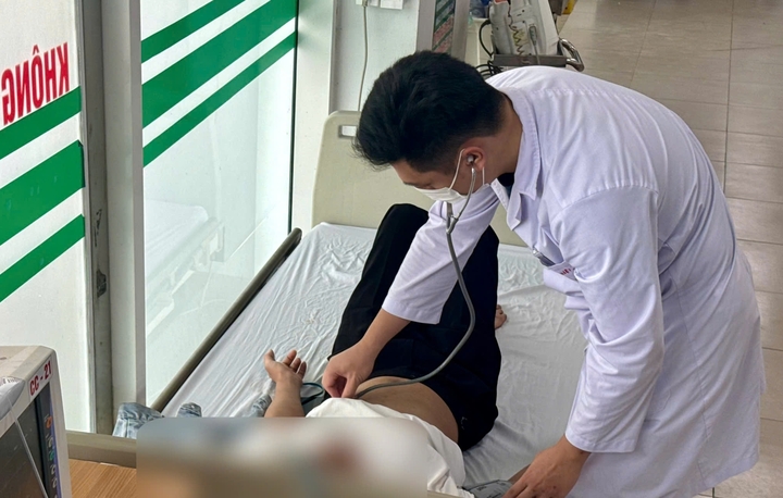 Nam shipper được bác sĩ thăm khám sau tai nạn khi giao hàng giữa trời nắng nóng. (Ảnh: Đặng Thanh)